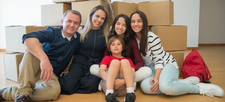 happy family sitting among moving boxes