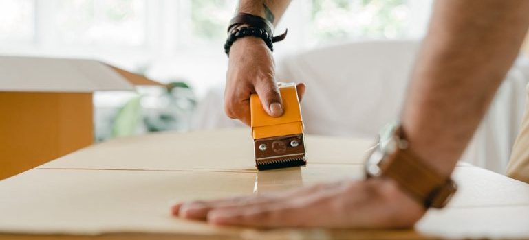 person taping a box