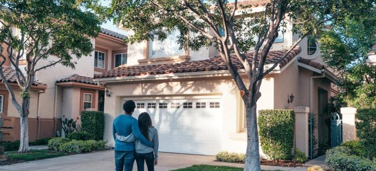 couple standing in front a house
