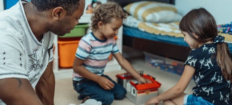 man and two kids playing