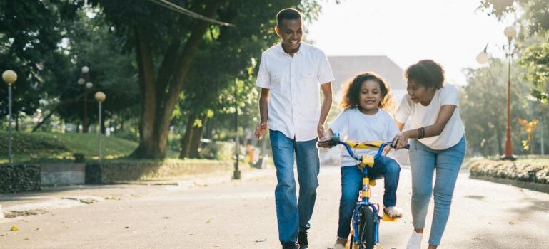 parents teaching a child how to ride a bike
