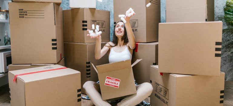 woman sitting among boxes