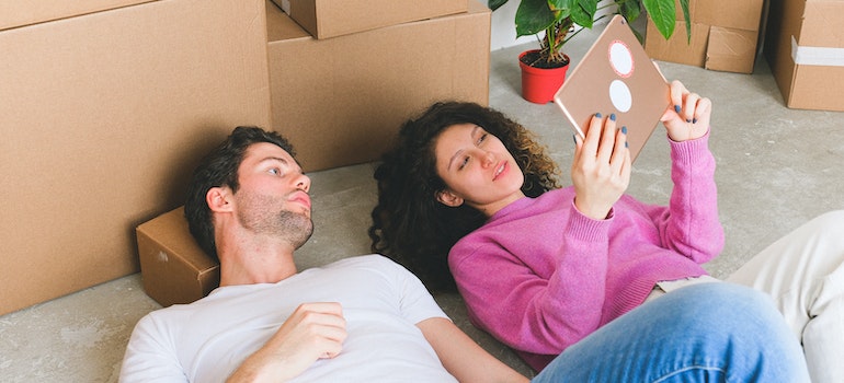 A couple laying on the floor next to the moving boxes