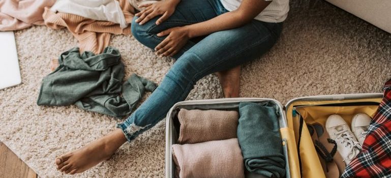 woman packing her suitcase after learning about how to move from a house in Mississippi Mills to a small apartment in Ottawa