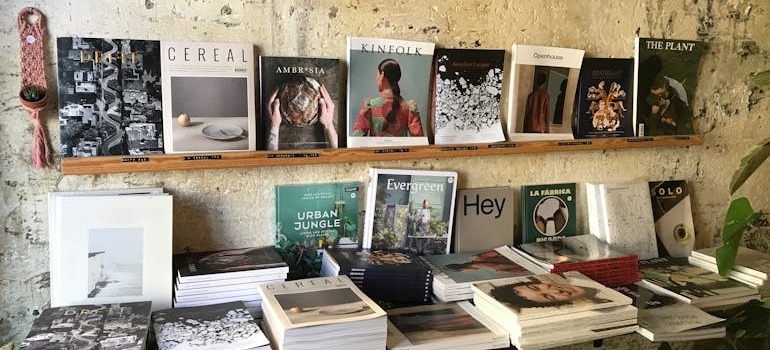 A person out of frame looking at magazines before they recycle household items