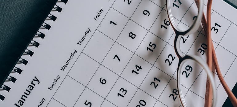 Brown framed eyeglasses on top of a calendar