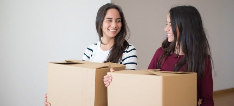 two young women holding boxes 