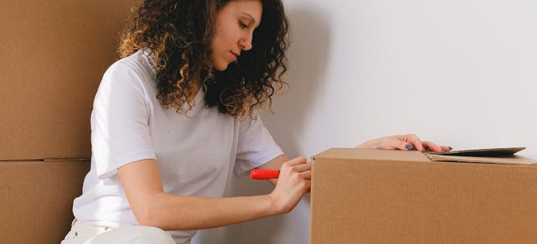 A woman labeling moving boxes