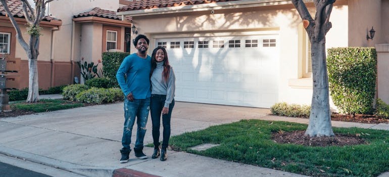A man and woman in front of their home