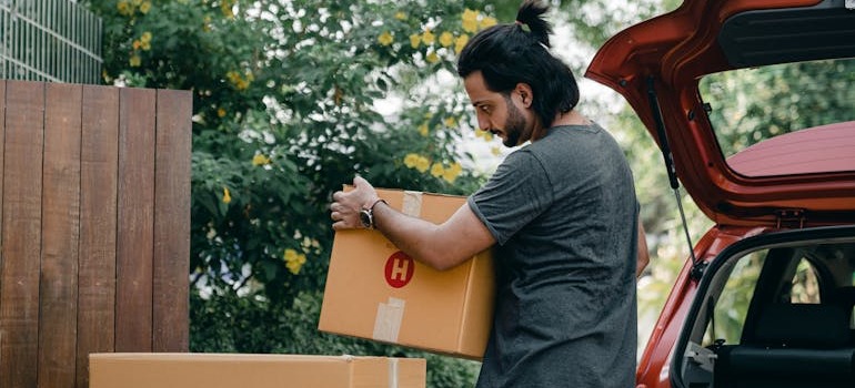 A man putting boxes into his car