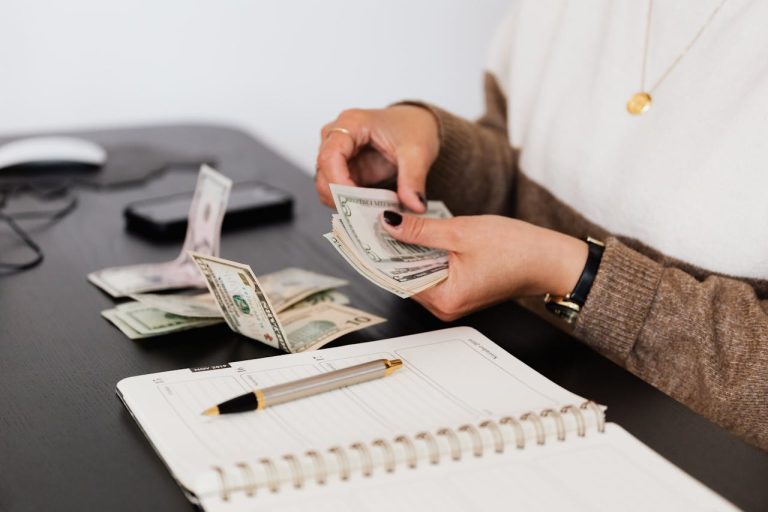A person counting money trying to create a moving budget and stick to it