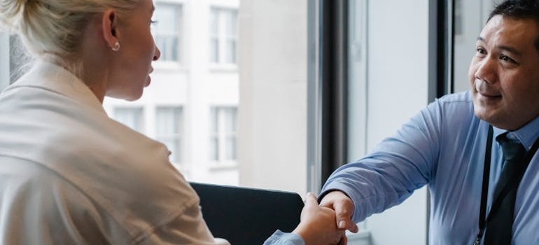 A man and woman shaking hands after talking about how a relocation can impact your mental health