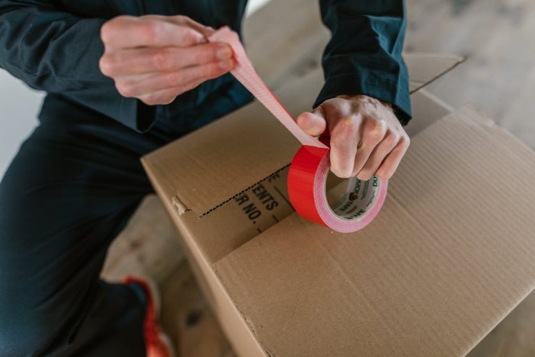 A person closing a box after going over the dos and don’ts of packing a storage unit
