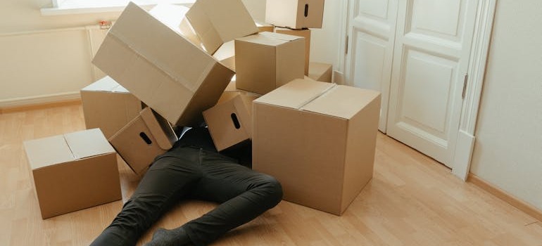 A person under cardboard boxes