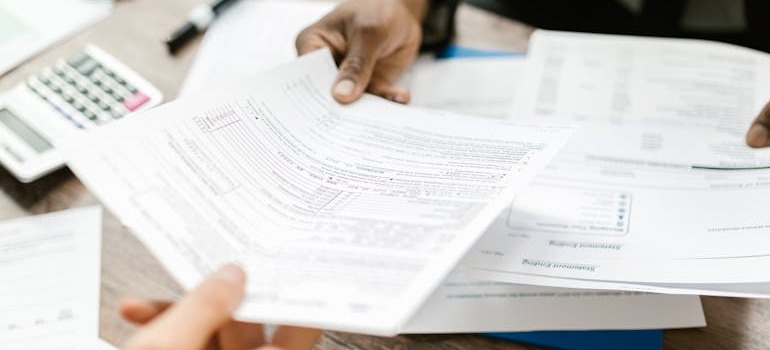 A person giving another person insurance papers