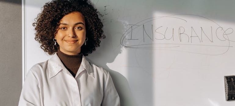 A woman in front of a white board with insurance written on it