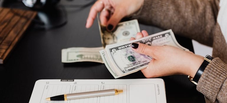 A person counting money to ensure understanding moving costs in Ottawa