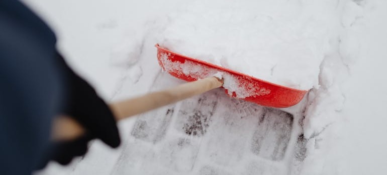 A man shoveling snow before a move during Ottawa’s snowiest months