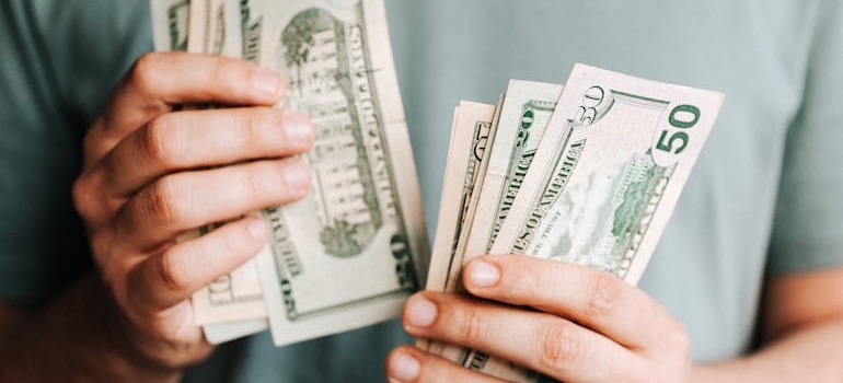 A person counting money before helping you hire movers in Kanata for your small move