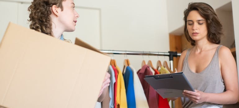 Two women going over what items to seel and donate, and discussing how to find the most affordable moving solutions in Ottawa
