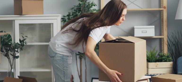 A woman transporting a moving box