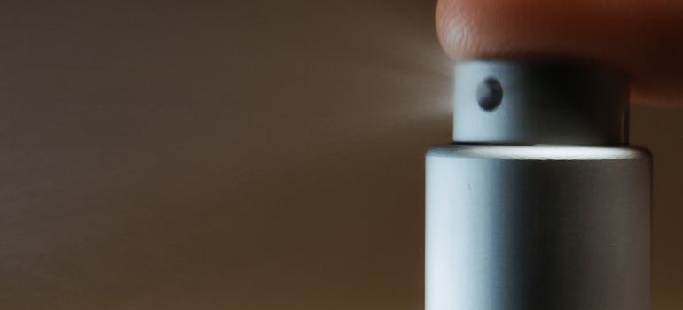 A close-up of a person's finger pressing a spray 