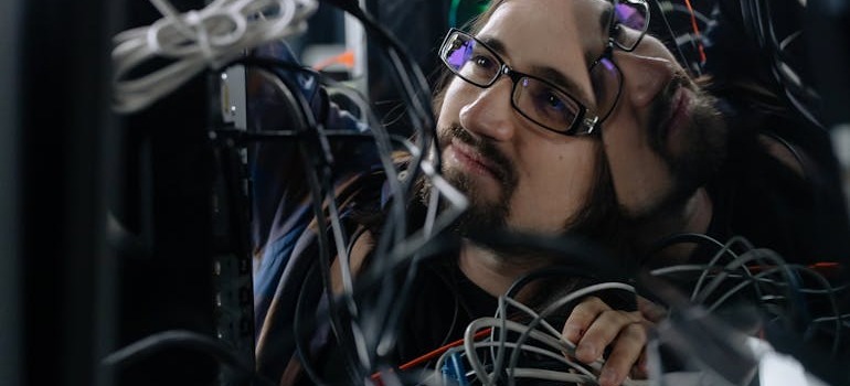 An employee looking at cables in an office