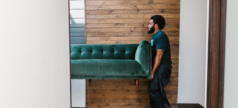A mover helping you relocate a sofa after successfully navigating Ottawa traffic & parking