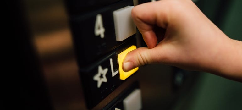 A person pressing a button in an elevator