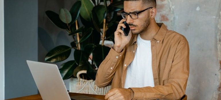 A person on a phone call looking at a laptop