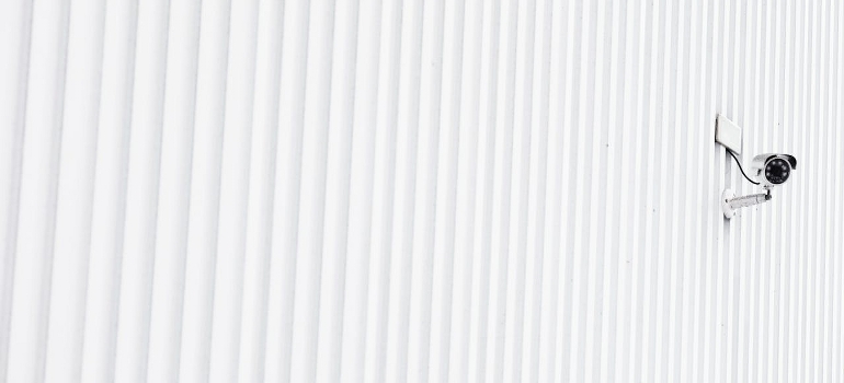 A security camera on a white wall. 