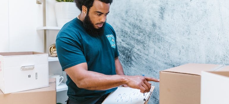 A person holding a list and checking moving boxes