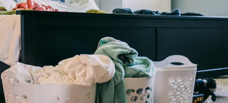 Bins with clothes beside a bed
