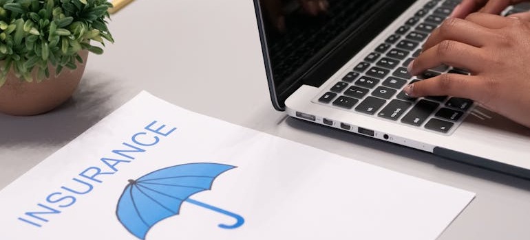 Insurance papers beside a laptop