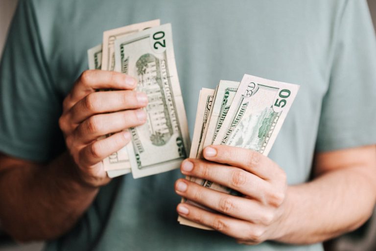 A person counting money, trying to figure out how to avoid extra fees when moving