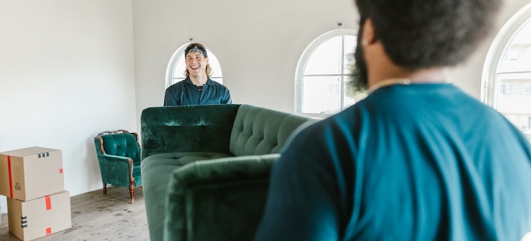 Two men are carrying a green couch to prepare your home for sale before your big Ottawa move. 