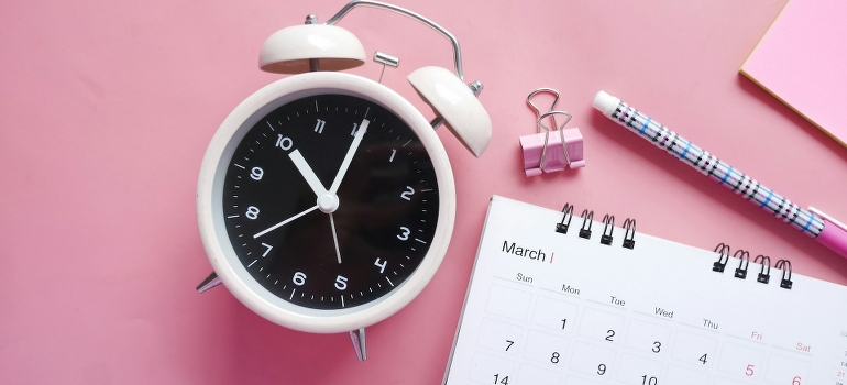 Analog clock and calendar on the desk. 