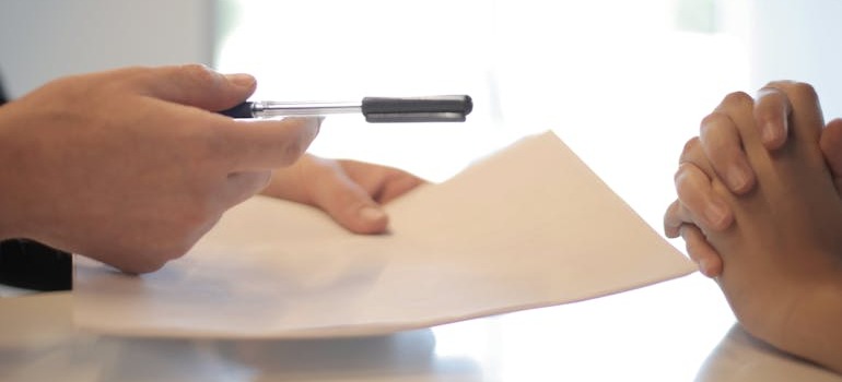 A person giving insurance papers to another person
