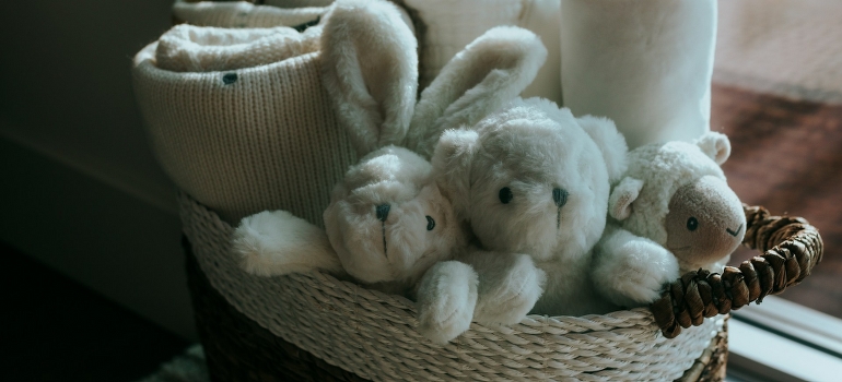 A basket filled with toys and blankets. 