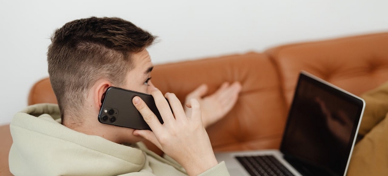 A student is having a phone call before moving into a college dorm.