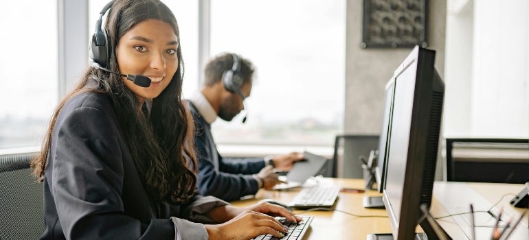 A smiling woman at the call center helps support every successful day in the life of a moving crew.