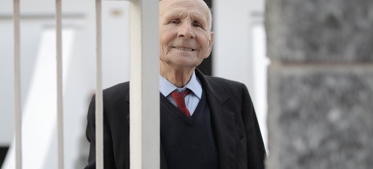 An elderly man opening a door